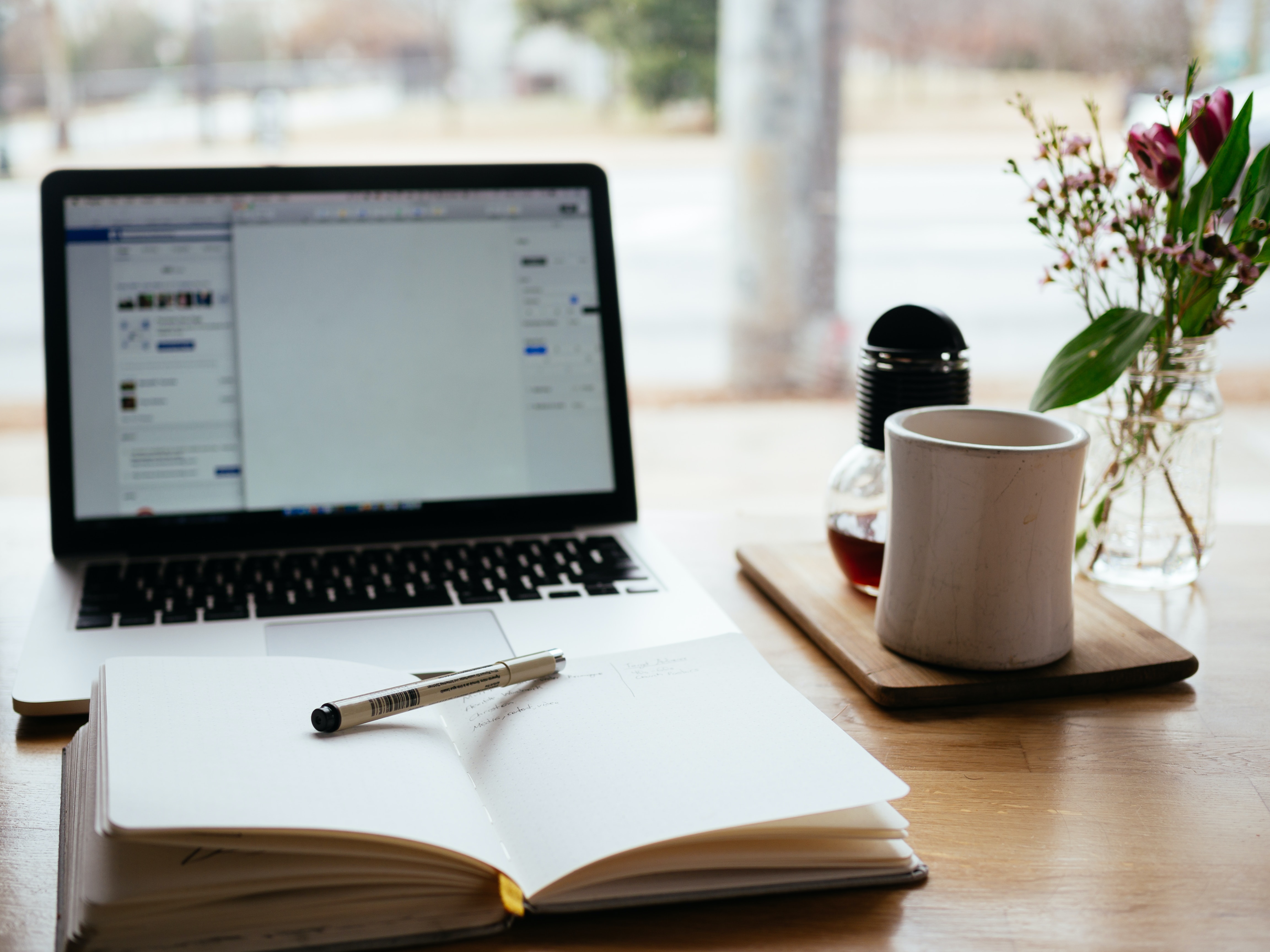 a desk setup with laptop and notebook - foreclosure refinance